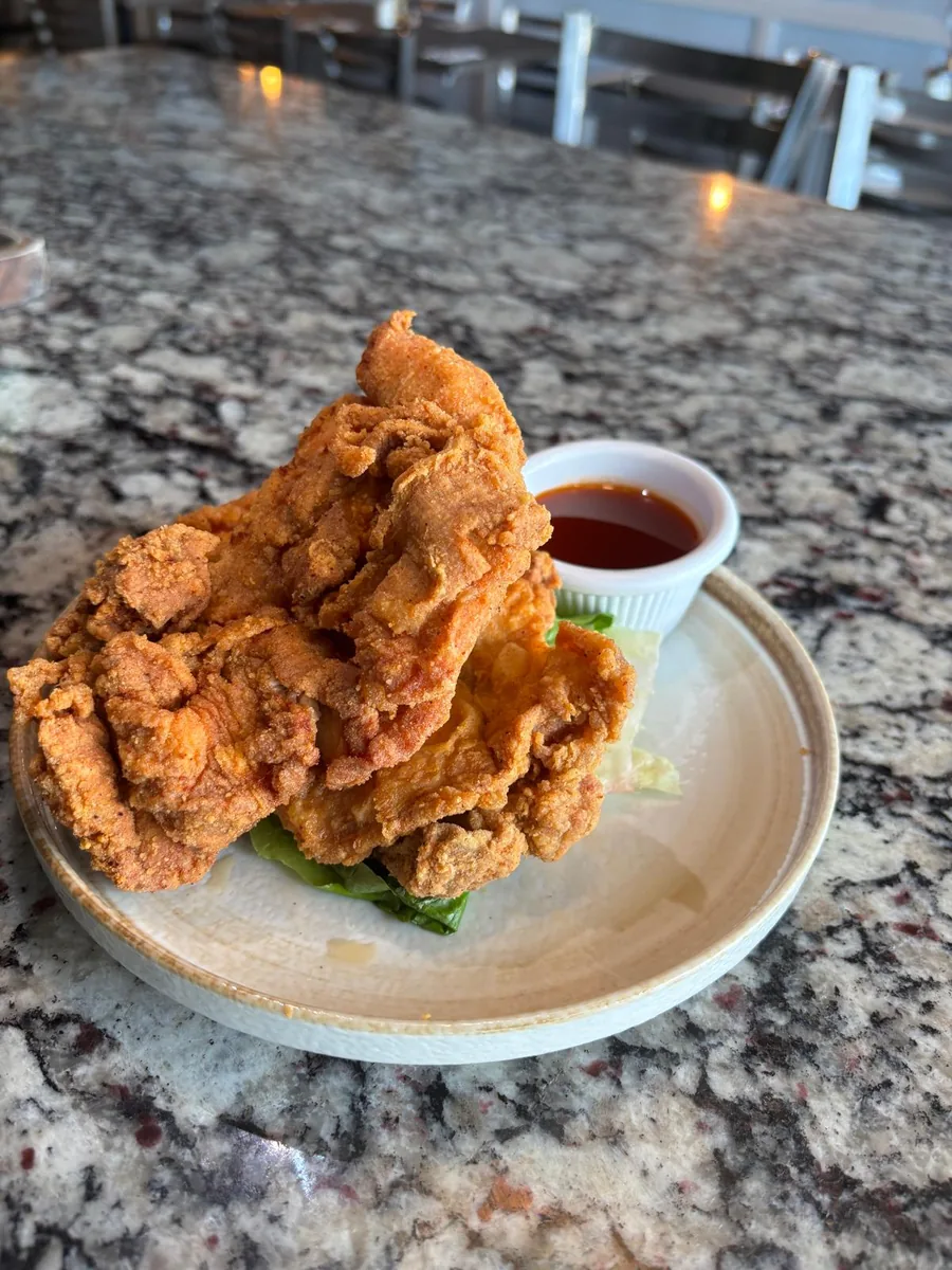 Two pieces of crispy golden fried chicken side at Estime's Cafe Colonia NJ